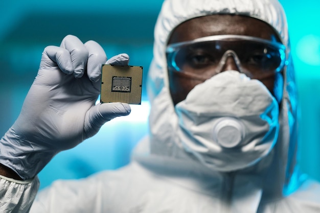 Gloved hand of young african scientist holding microchip