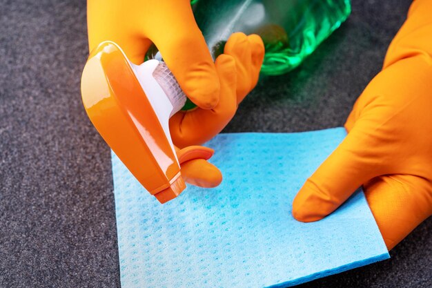 Gloved hands with sponge and cleaning spray on ceramic title surface cleaning concept