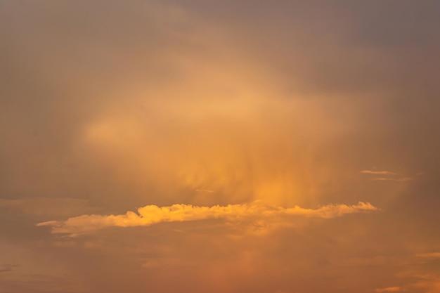 写真 薄明色の黄金の空と雲と劇的なカラフルな雨雲空の夕日の輝きグラデーションカラー空のテクスチャ抽象的な自然の背景