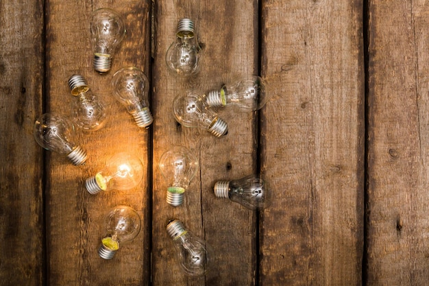 glowing bulb over wooden background uniqueness concept