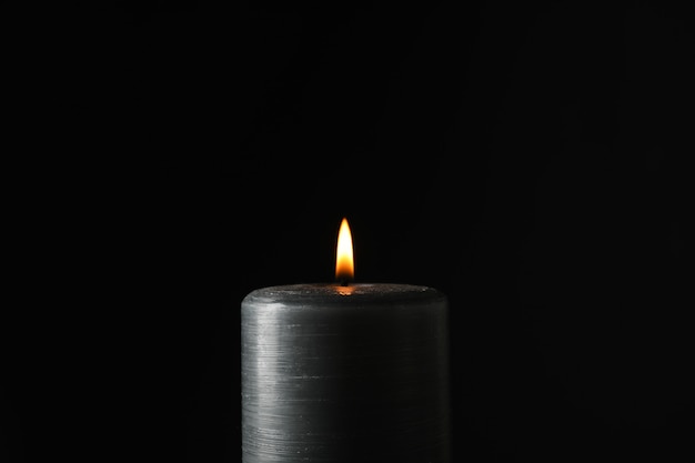 Glowing candle on black