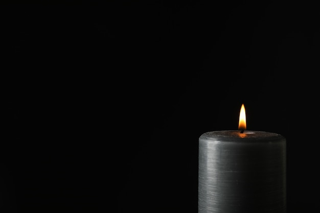 Glowing candle on black