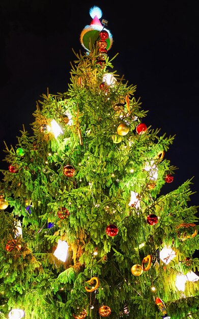 Albero di natale incandescente chiamato tesori degli elfi in piazza duomo nella vecchia riga, lettonia. inverno. a tarda sera. fiera di strada e di festa nella città europea decorazione dell'avvento con oggetti di artigianato su bazaar