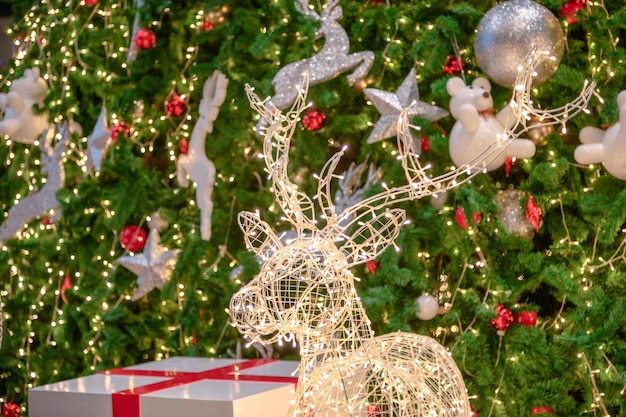 Foto cervo luminoso con decorazione leggera con giocattolo sullo sfondo dell'albero di natale