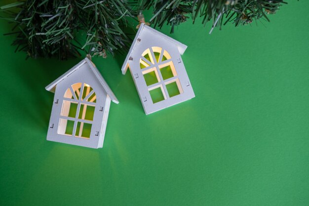 glowing garland of wooden  cozy houses on a green new year christmas concept