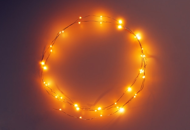 Glowing golden electric garland on a gray 