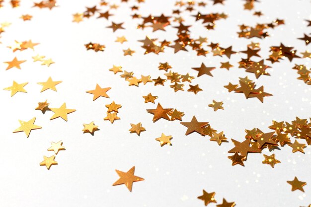 Glowing golden stars confetti scattered on a blue pastel background