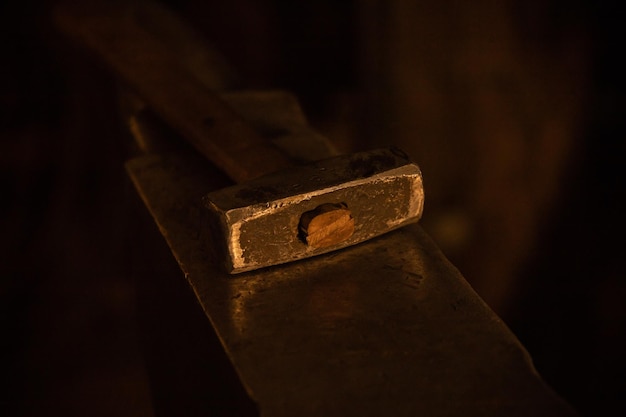 Glowing hammer lying on the anvil in dark lighting