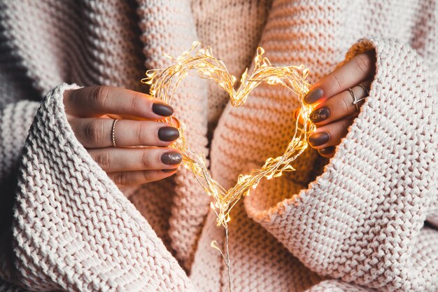 Glowing heart in the hands of a woman. Happy Valentine's day.