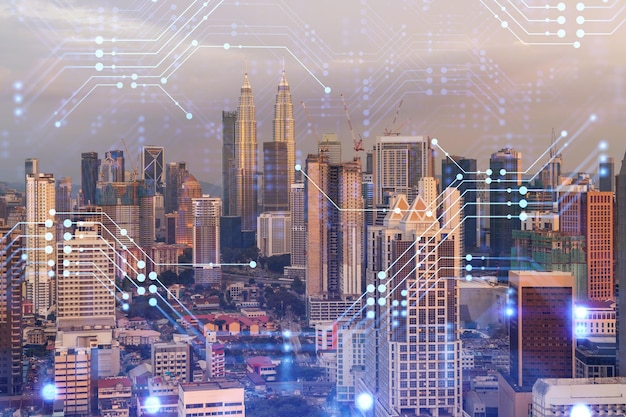 Glowing hologram of technological process aerial panoramic cityscape of Kuala Lumpur at sunset KL is the largest innovative hub of tech services in Malaysia Asia Multi exposure