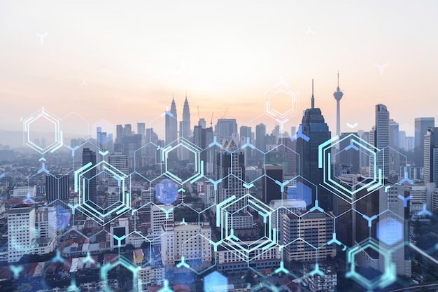 Glowing hologram of technological process aerial panoramic cityscape of Kuala Lumpur at sunset KL is the largest innovative hub of tech services in Malaysia Asia Multi exposure