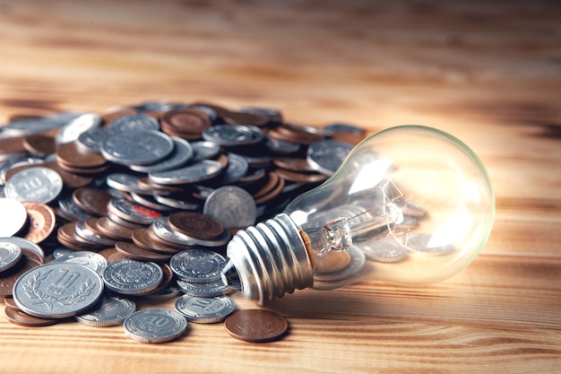 Glowing lamp and coins on a dark scene