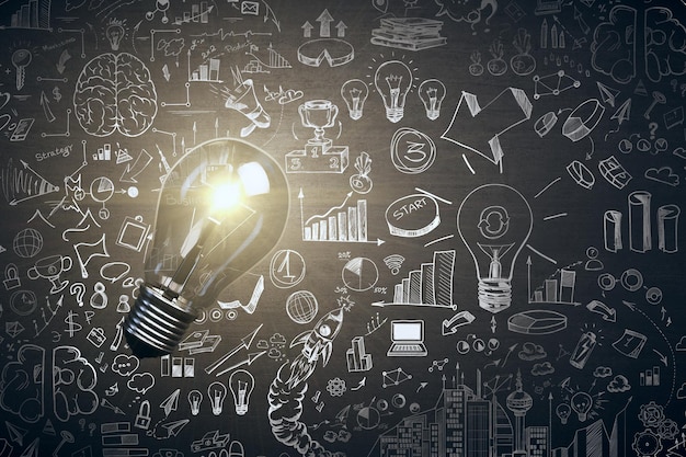 Glowing light bulb and business sketch on blackboard