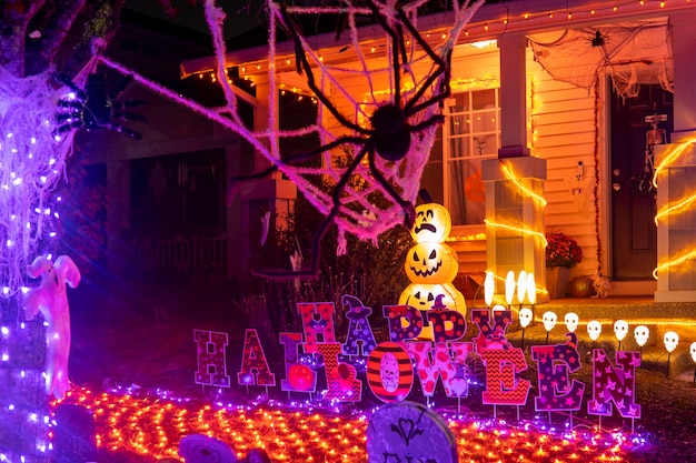 Glowing outdoor decorations with spiders, pumpkins, ghosts and inscription Happy Halloween