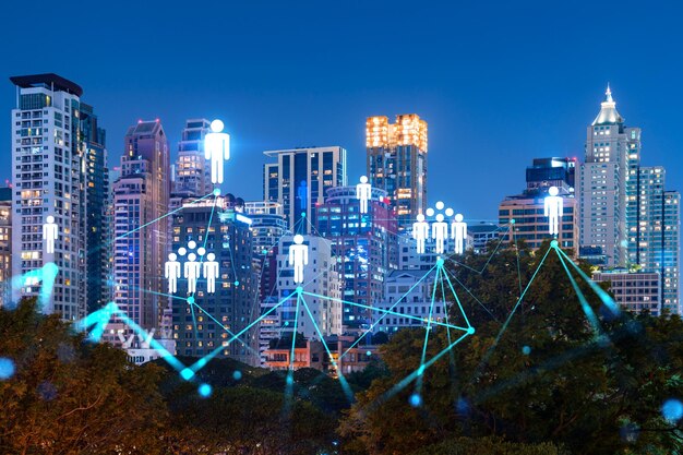 Glowing social media icons on night panoramic city view of bangkok asia the concept of networking and establishing new connections between people and businesses double exposure