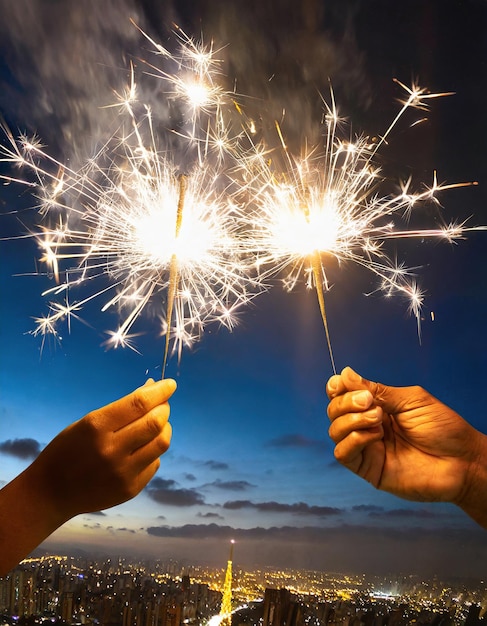 glowing sparklers in hands at a background city