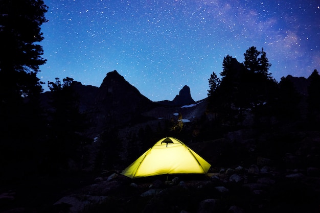 Glowing tent in the background of night starry sky