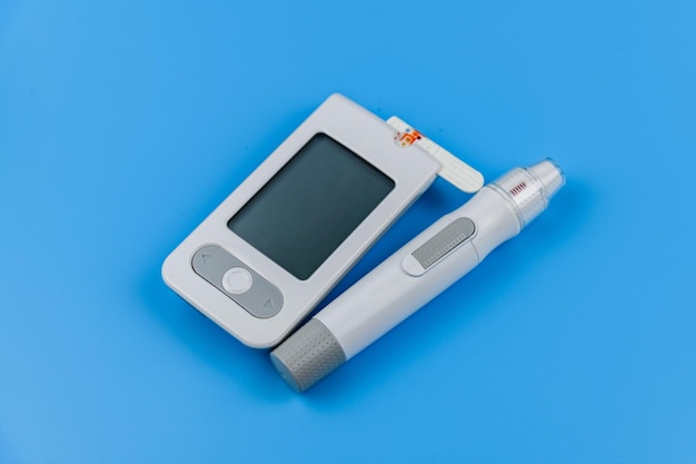 파란색 배경에 고립 된 포도당 측정기 당을 측정하는 의료 장치
