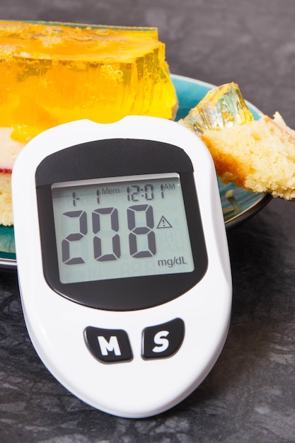 Glucometer met hoog suikergehalte en romige fruitcake met gelei Voeding bij diabetes Heerlijk toetje voor verschillende gelegenheden