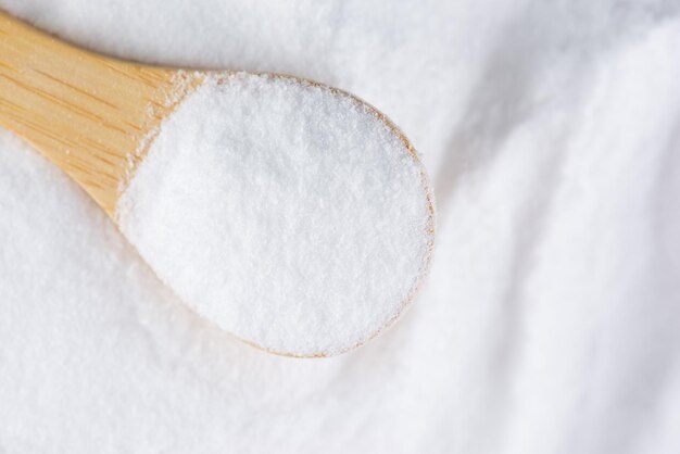 Glucose or grape sugar in a spoon on a wooden board top view