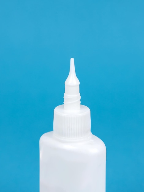 Glue bottle isolated on blue background Close up