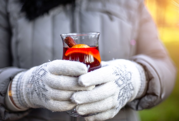 glühwein in een glas warme glühwein herfst mandarijnen gluhwein bij dames handen in handschoenen