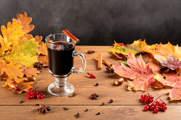 Glühwein met kruiden en herfst decor op houten tafel. Stilleven, seizoengebonden en vakantieconcept.