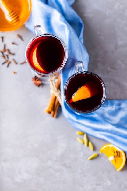 Glühwein met sinaasappel en kruiden in glazen mokken