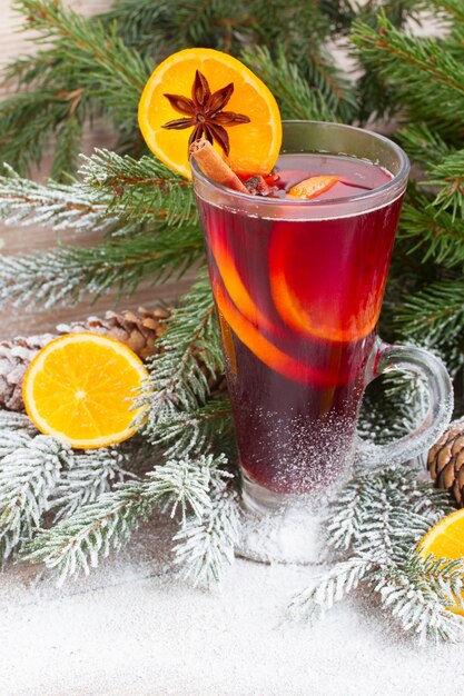 Glühwein met verse kerst groenblijvende boom in sneeuw op houten achtergrond