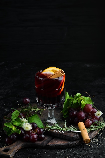 Glühwein warme wijn met sinaasappelappel en kaneel in het glas bovenaanzicht op een zwarte achtergrond