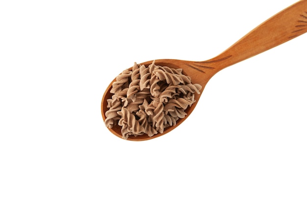 Фото Льняные макароны без глютена в ложке крупным планом сырые фузилли из льняной муки pasta di lino