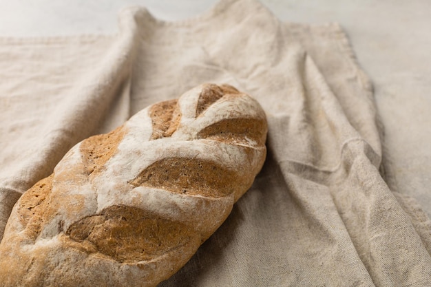 Gluten free fresh bread in kitchen towel on light background