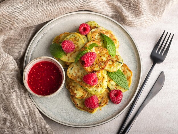 Gluten-free zucchini pancakes with raspberries and raspberry jam. Healthy food concept, summer food.