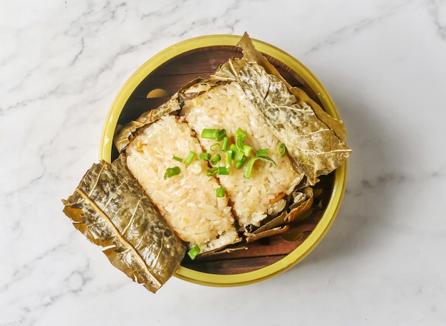 蓮の葉のもち米は、中国料理とタイ料理の背景上面に分離された料理を提供