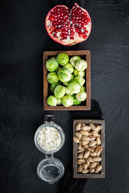 Gnarly knoflook Brussel ingrediënten, op zwarte gestructureerde achtergrond, bovenaanzicht