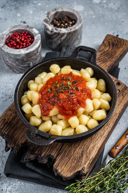 Gnocchi pasta met tomatensaus en Parmezaanse kaas Grijze achtergrond Bovenaanzicht