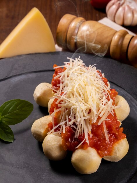 Gnocchi with natural organic tomato sauce without pesticides with grated Parmesan cheese and basil leaves..