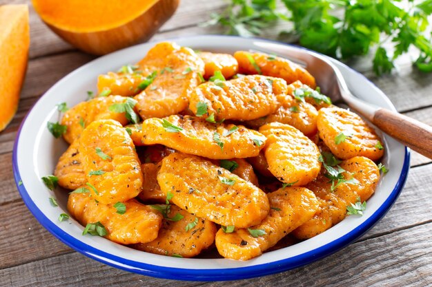 Gnocchi with a pumpkin on the plate. Italian dumplings with butter. Autumn meal.