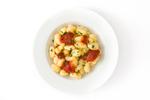 Foto gnocchi con salsa al pomodoro in zolla isolata sulla vista superiore bianca