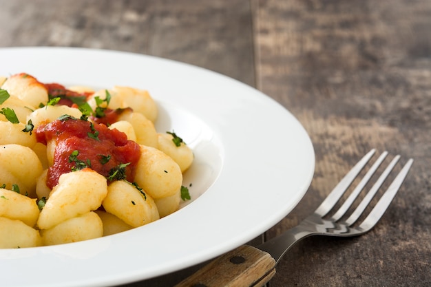 Gnocchi with tomato sauce on wooden