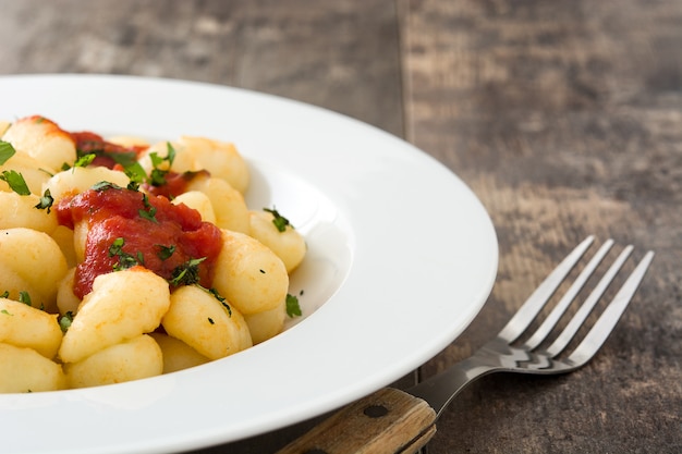 Foto gnocchi con salsa al pomodoro su di legno