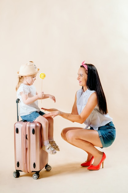 Go on an adventure. Happy family preparing for the journey. Mom and daughter are packing suitcases for the trip.