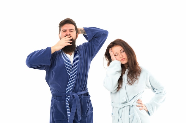Go to bed. All day pajamas. Sleepy people white background. Couple in love bathrobes. Drowsy and weak in morning. Morning routine. Couple sleepy faces domestic clothes. Sleep time. Exhausted people.