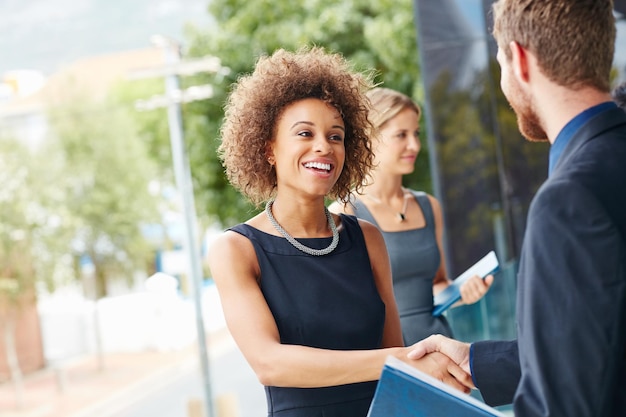 Go outside and meet new people Shot of a businesswoman and businessman shaking hands outdoors