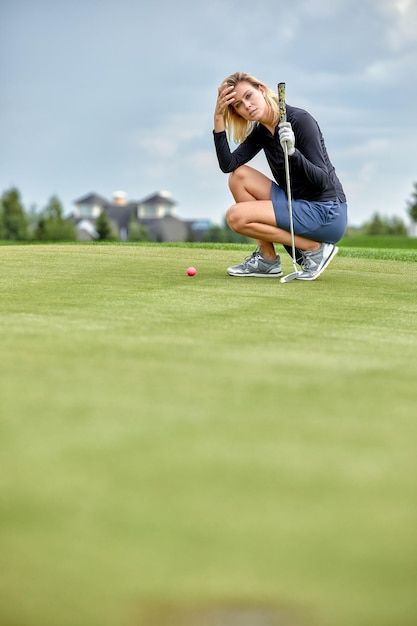 Goal concept copy space women golfing time holding golf\
equipment on green field background the pursuit of excellence\
personal craftsmanship royal sport sports banner