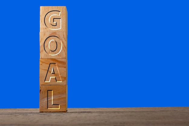 Goal engraved on wooden cubes on a blue background