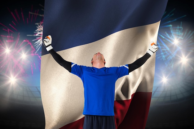 Goalkeeper celebrating a win against fireworks exploding over football stadium and france flag