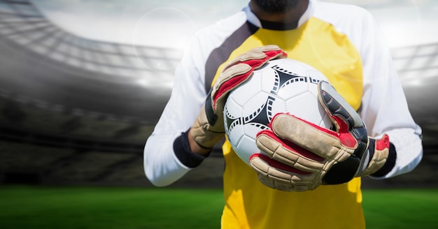 Goalkeeper holding football in stadium