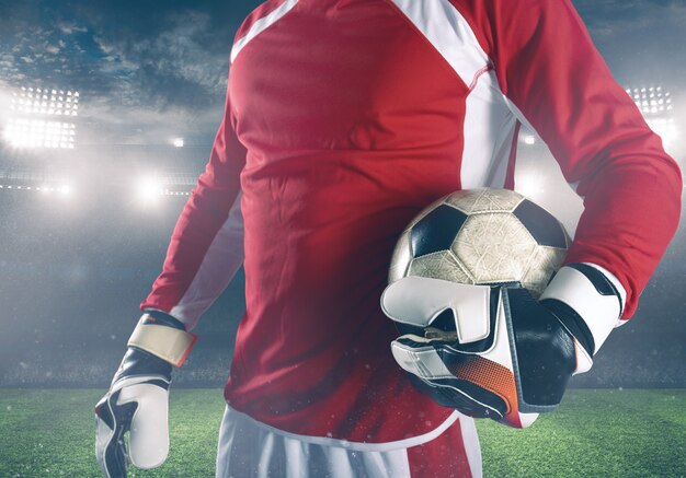 Goalkeeper ready to play with ball in his hands at the stadium