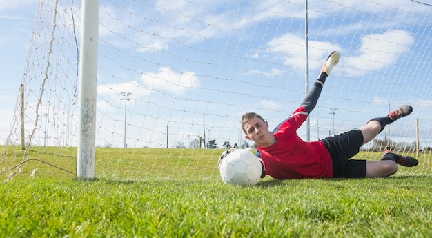 Goalkeeper in red making a save 